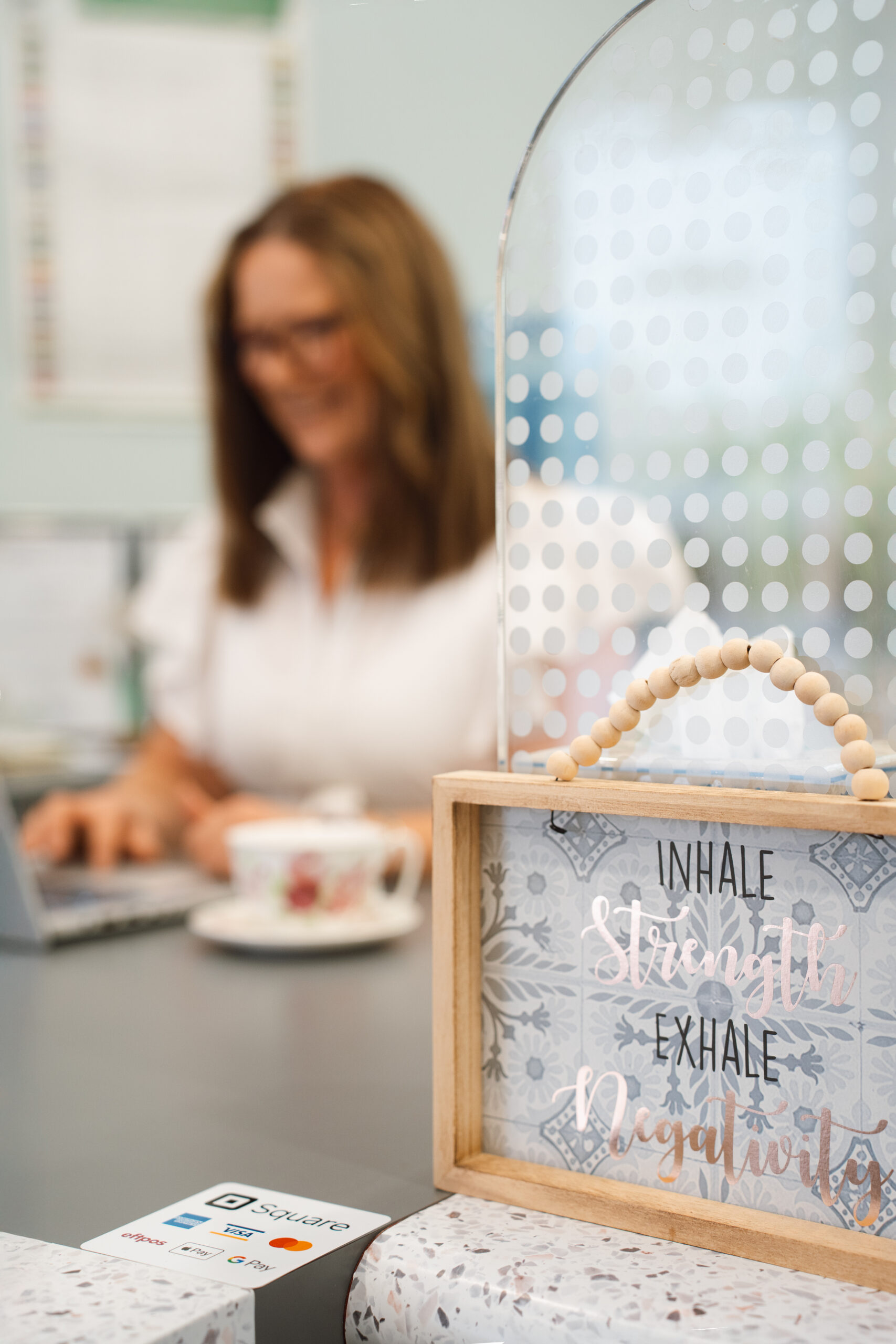 Motivational sign reading “Inhale strength, exhale negativity” in naturopath Louise’s clinic.