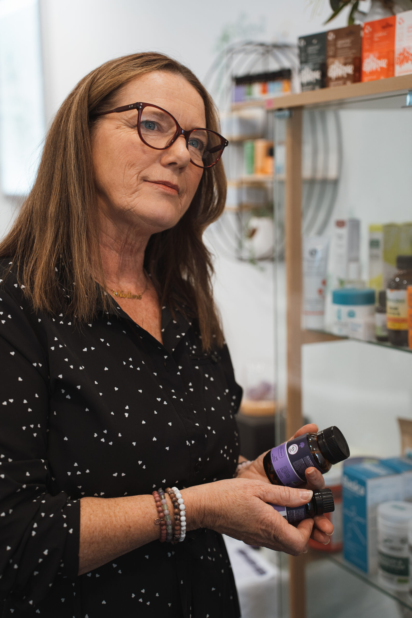 Naturopath Louise Mace holding practitioner-grade herbal supplements.